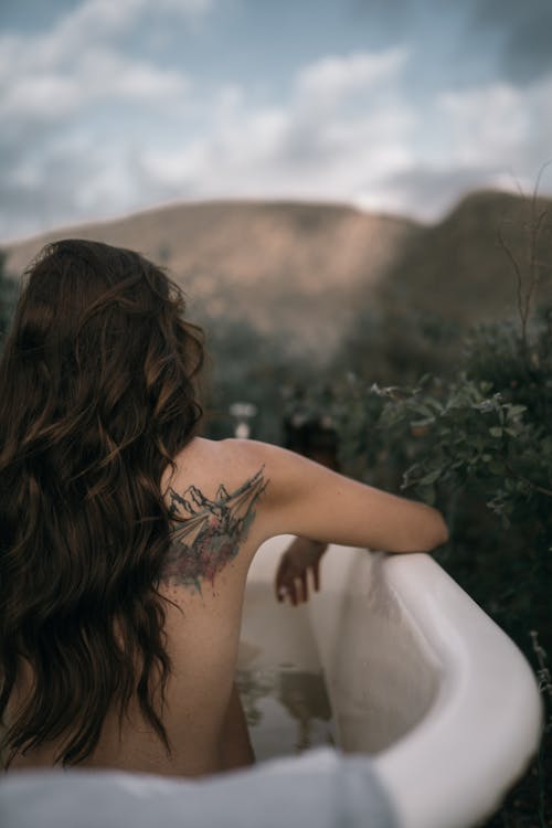 Free Back View of a Woman in a Bathtub Stock Photo