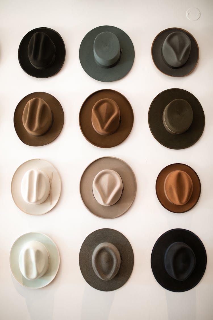 Assorted Fedora Hats Hanging On The Wall