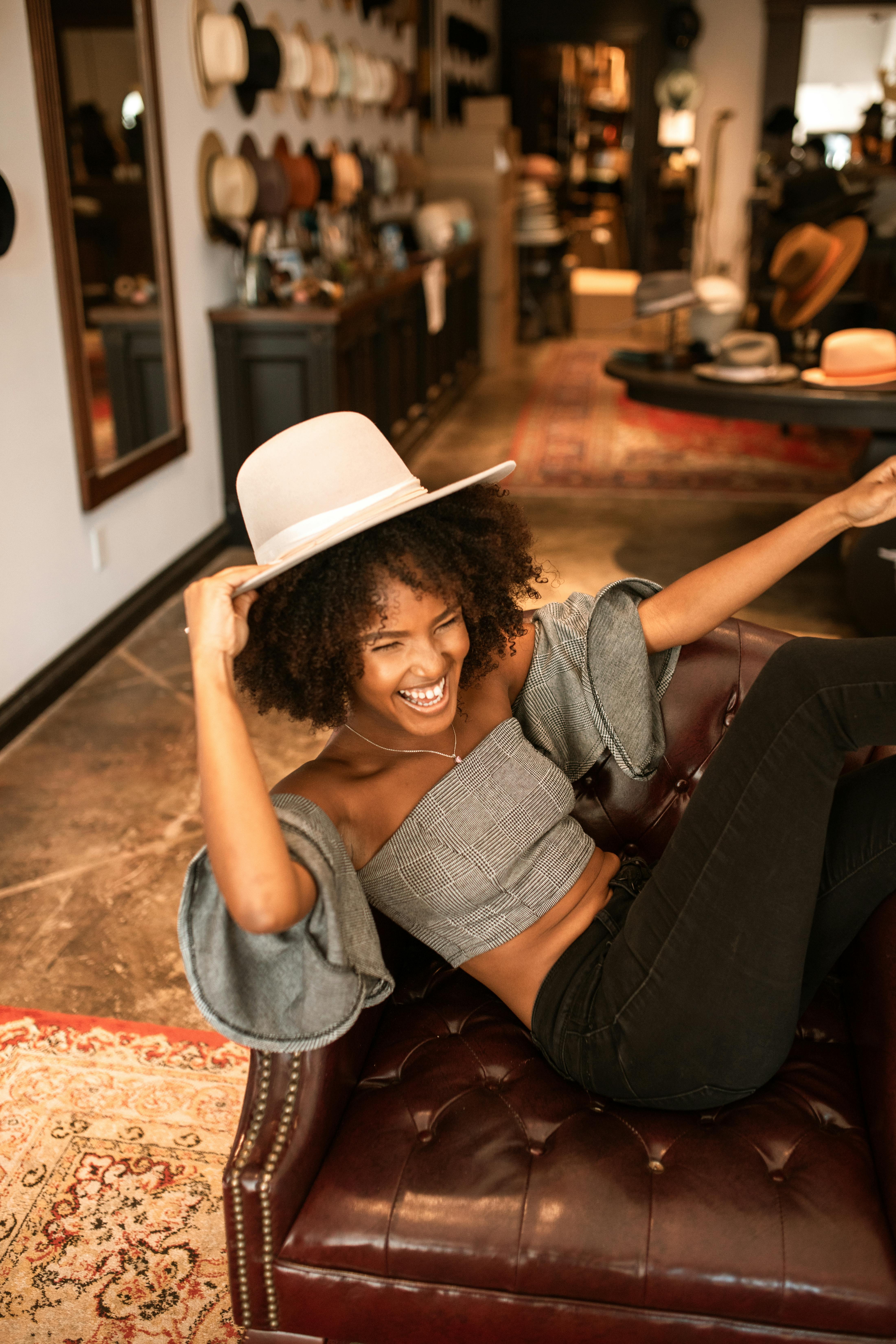 woman in gray shirt and black pants sitting on brown leather armchair