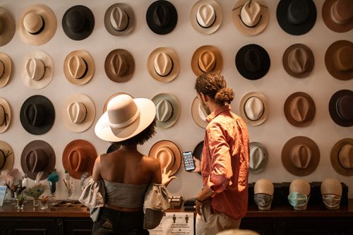 Free A stylish couple exploring a hat boutique, showcasing diverse headwear. Stock Photo