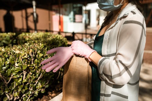 Free Close-Up Shot of a Person in a White Coat Wearing a Pink Surgical Gloves Stock Photo
