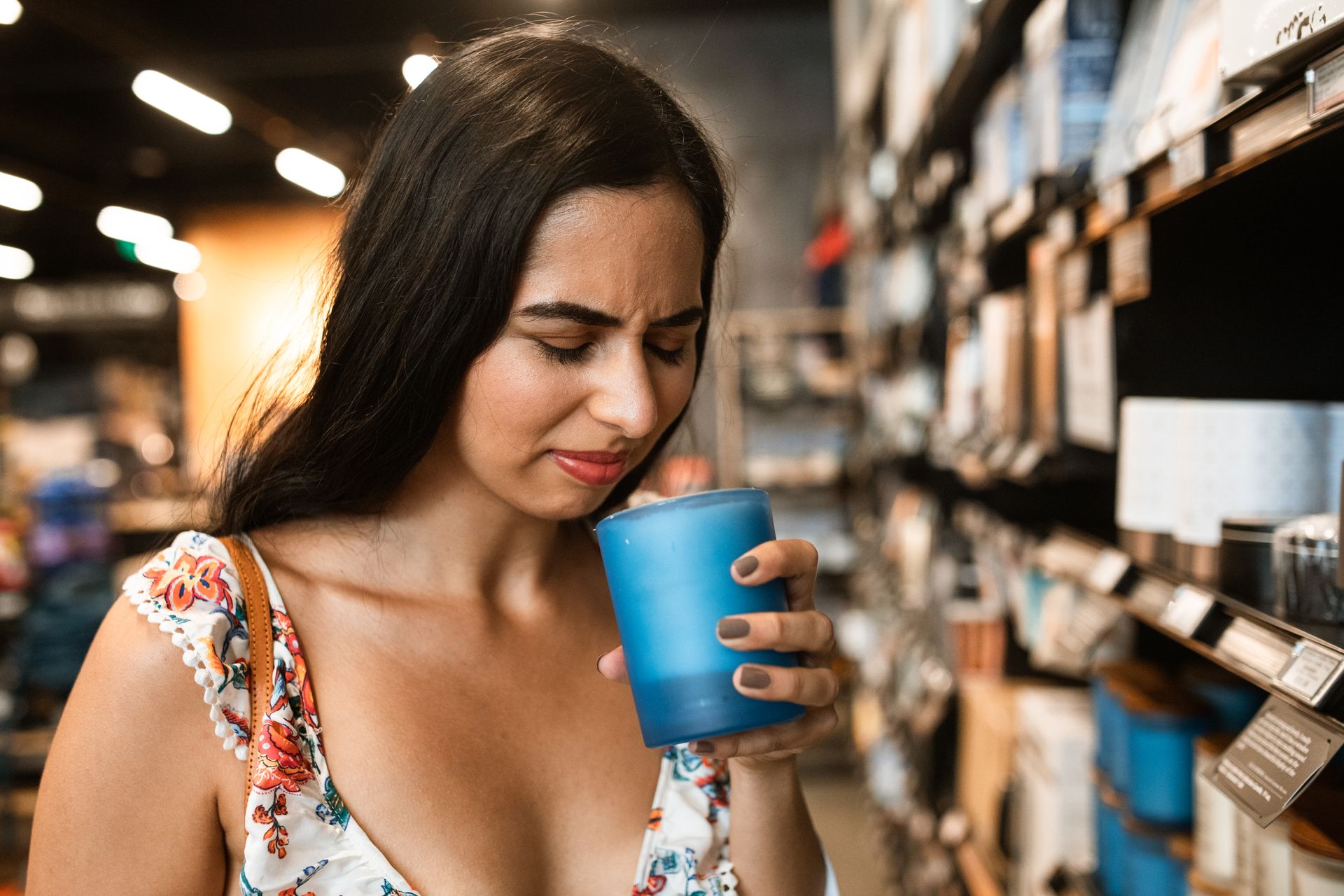 Woman in Floral Dress Smelling Unpleasant Candle