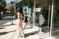 白天，两名女性在商店外社交，强调购物安全做法