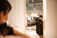 疫情期间，一名女子戴着口罩在商店试穿衣服