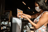 一名妇女在公共场所使用洗手液分配器，强调卫生和安全