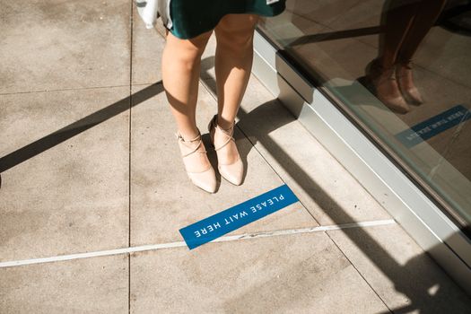 A Person Standing near a Signage on the Ground