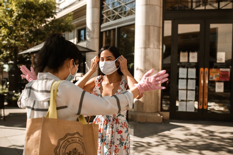 Close-Up Shot Of Two Women Wearing Face Masks While Talking Outside