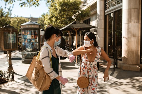 Free Two Women Wearing Face Masks Laughing Together Stock Photo