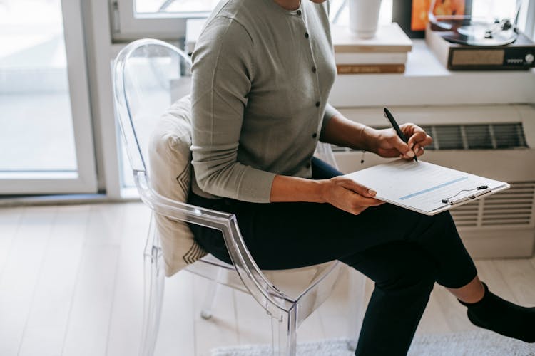 Crop Woman Writing On Clipboard