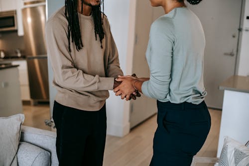 Crop black man shaking hands with unrecognizable therapist