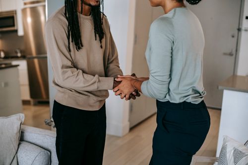 Free Side view of unrecognizable African American male client with dreadlocks greeting anonymous black female psychologist in room during session with blurred background Stock Photo