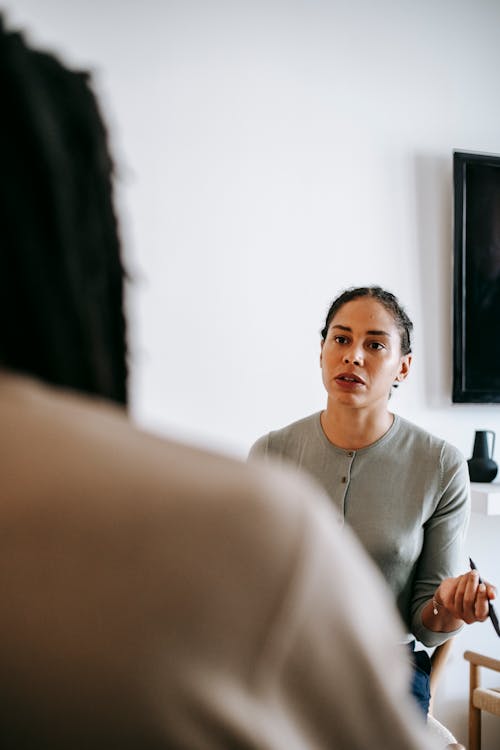 Concentrated ethnic female psychologist talking to client