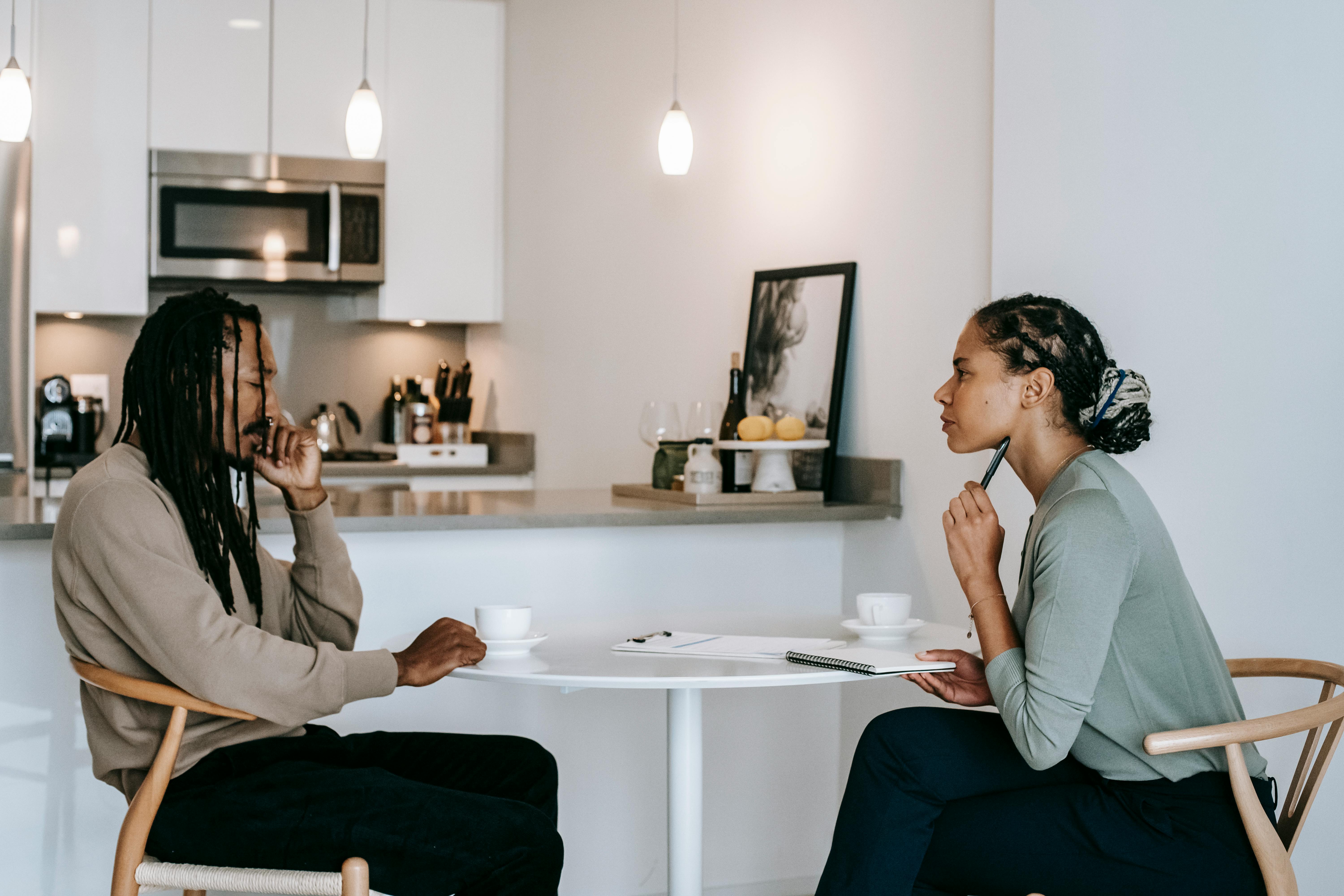 frustrated black man sharing problems with attentive female psychologist