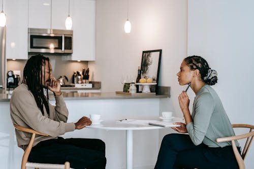 Free Frustrated black man sharing problems with attentive female psychologist Stock Photo