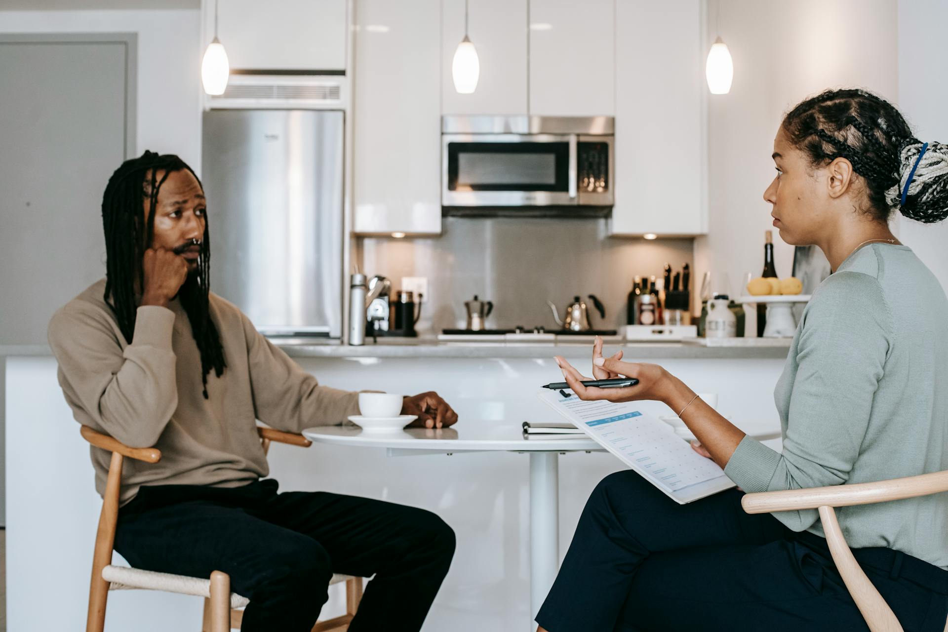 Ethnic woman discussing treatment with preoccupied black male patient