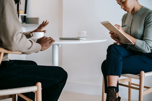 Consultante De Cultures Ethniques Parlant Au Client Et Prenant Des Notes