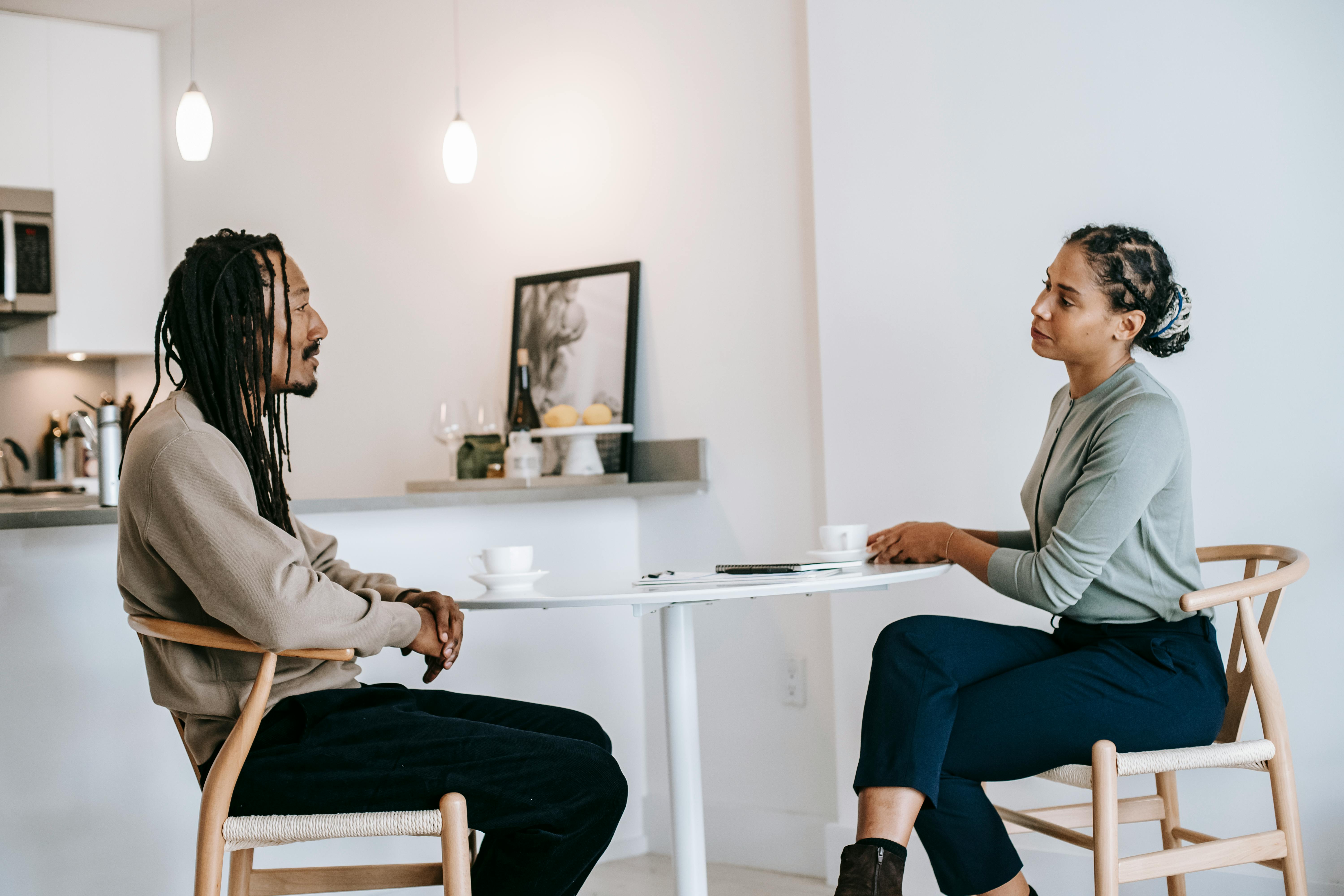 black man sharing problems with focused female consultant