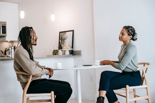 Black man sharing problems with focused female consultant