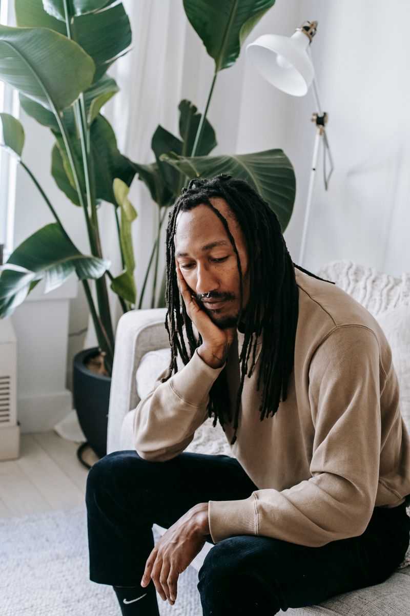 A Black man rests at home, eyes closed. Persistent fatigue and low energy can point to low testosterone, which a simple blood test can check.