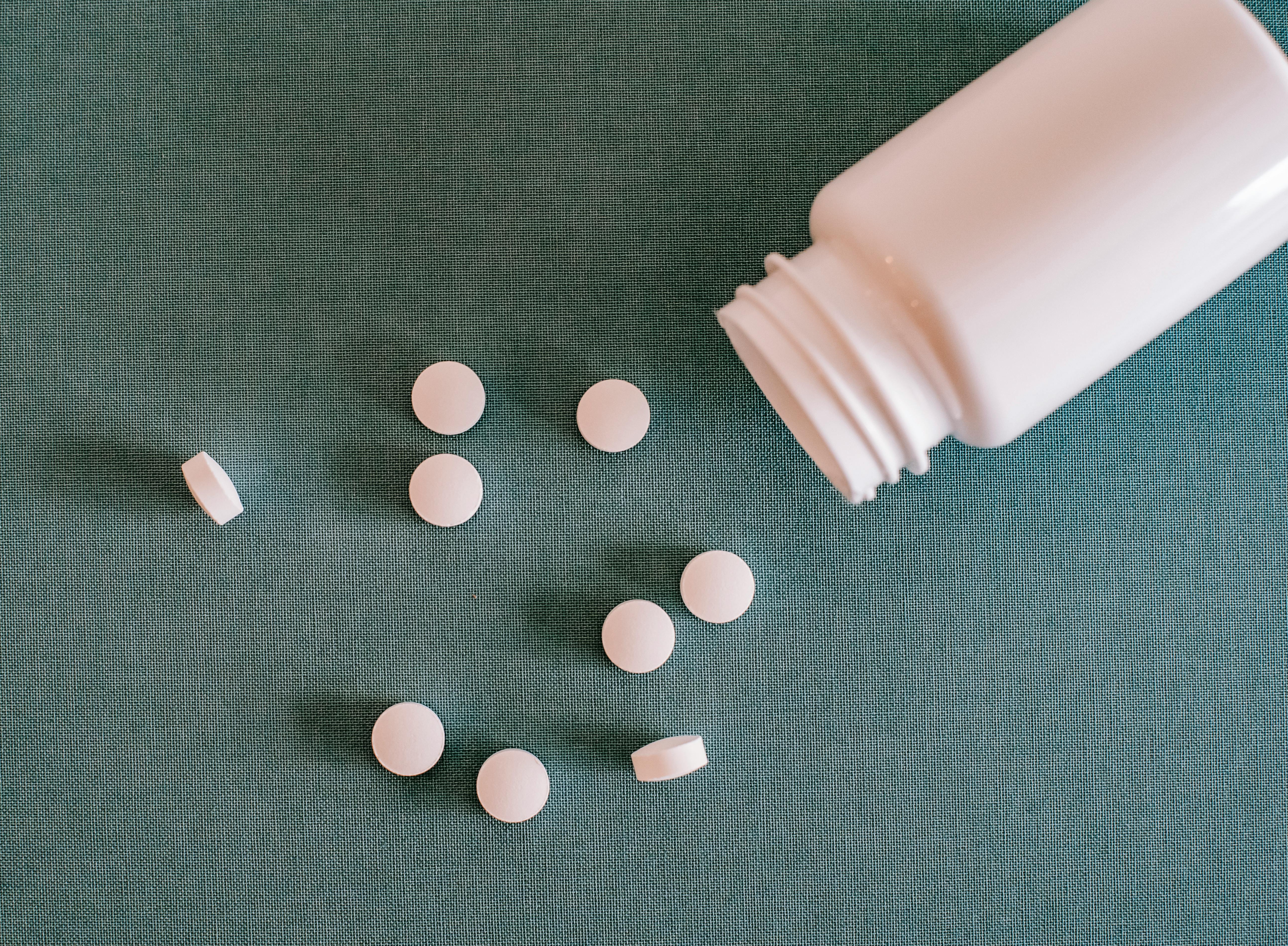 pile of white pills with container