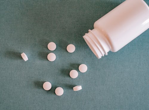 Pile of white pills with container