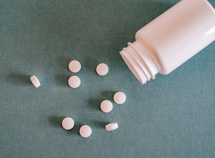 Pile Of White Pills With Container