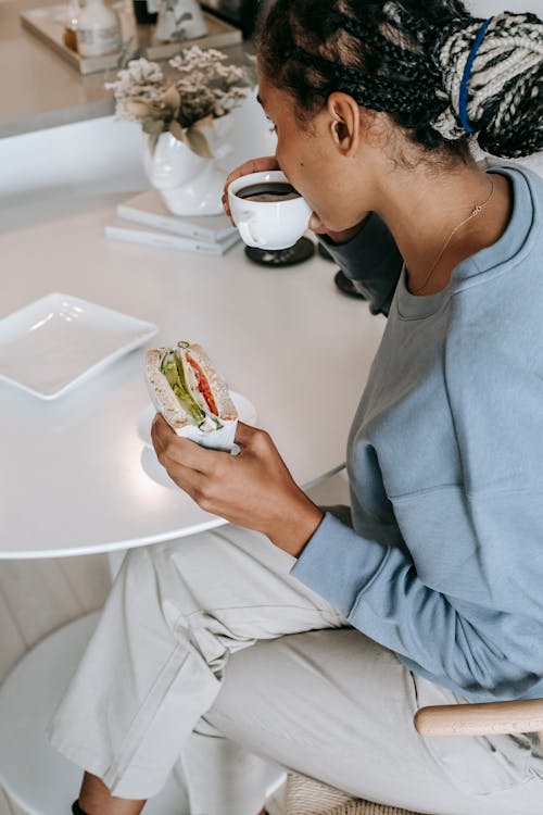 Free Black woman having breakfast in kitchen Stock Photo