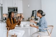 Side view of young African American male with dreadlocks in casual outfit having argument with African American 
dissatisfied female