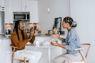 Side view of young African American male with dreadlocks in casual outfit having argument with African American
dissatisfied female