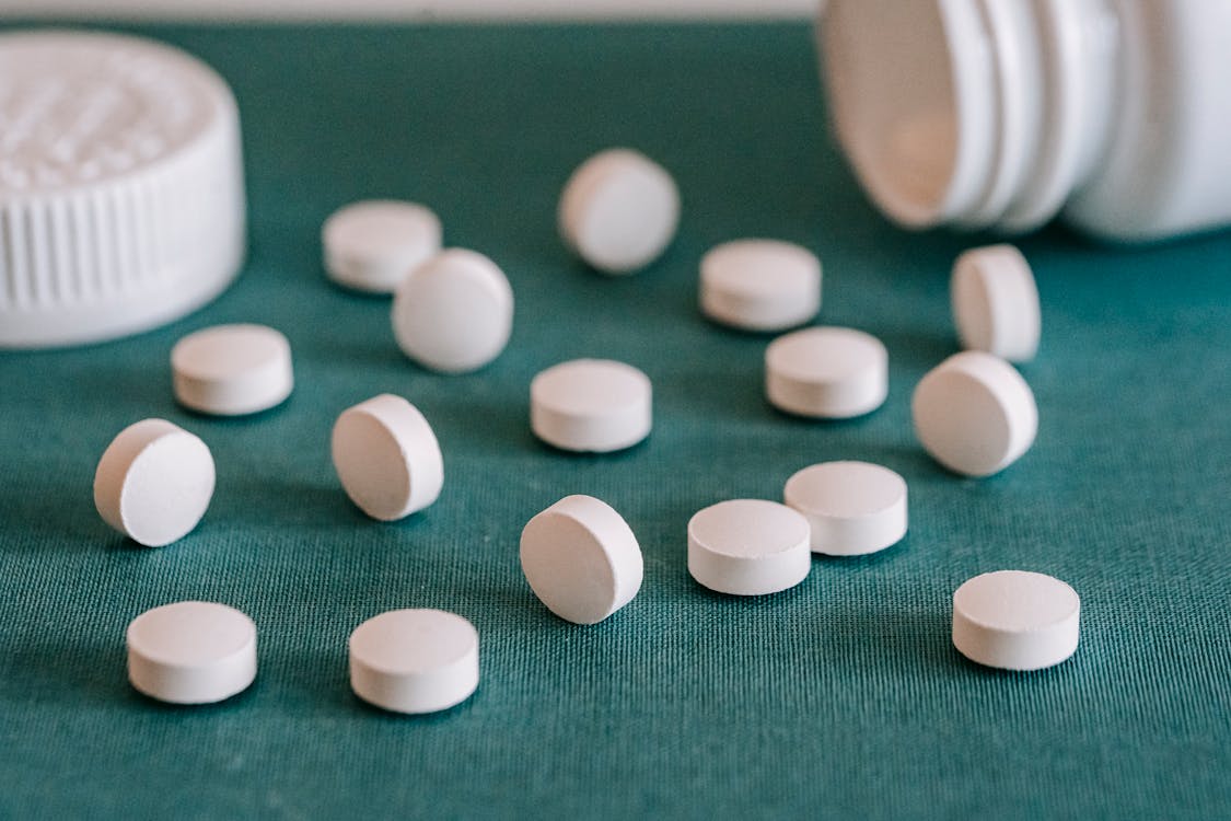 Free White pills spilled on table Stock Photo
