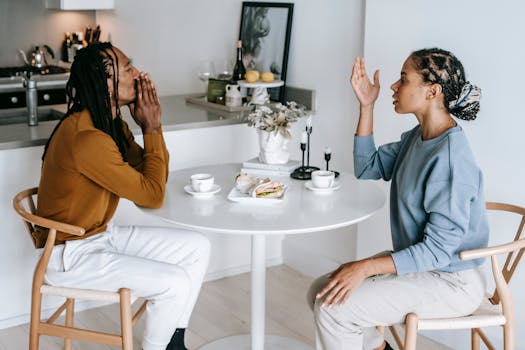 A couple in an intense conversation at a kitchen table, highlighting relationship dynamics.