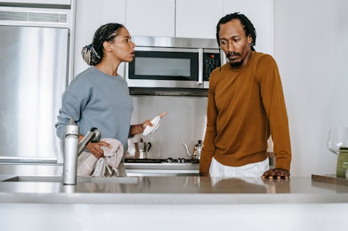 Black couple talking on kitchen