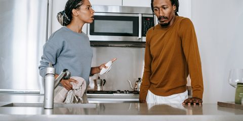 African American guy and lady in casual clothes standing and arguing in kitchen in daytime