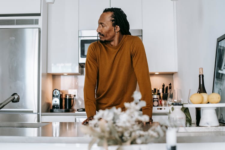 Black Man Standing Near Counter At Kitchen