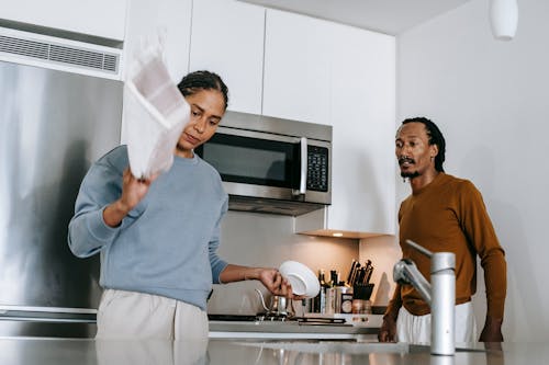 Black lady and guy arguing in kitchen