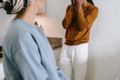 Young African American couple standing in room and arguing with each other while wearing casual clothes at home