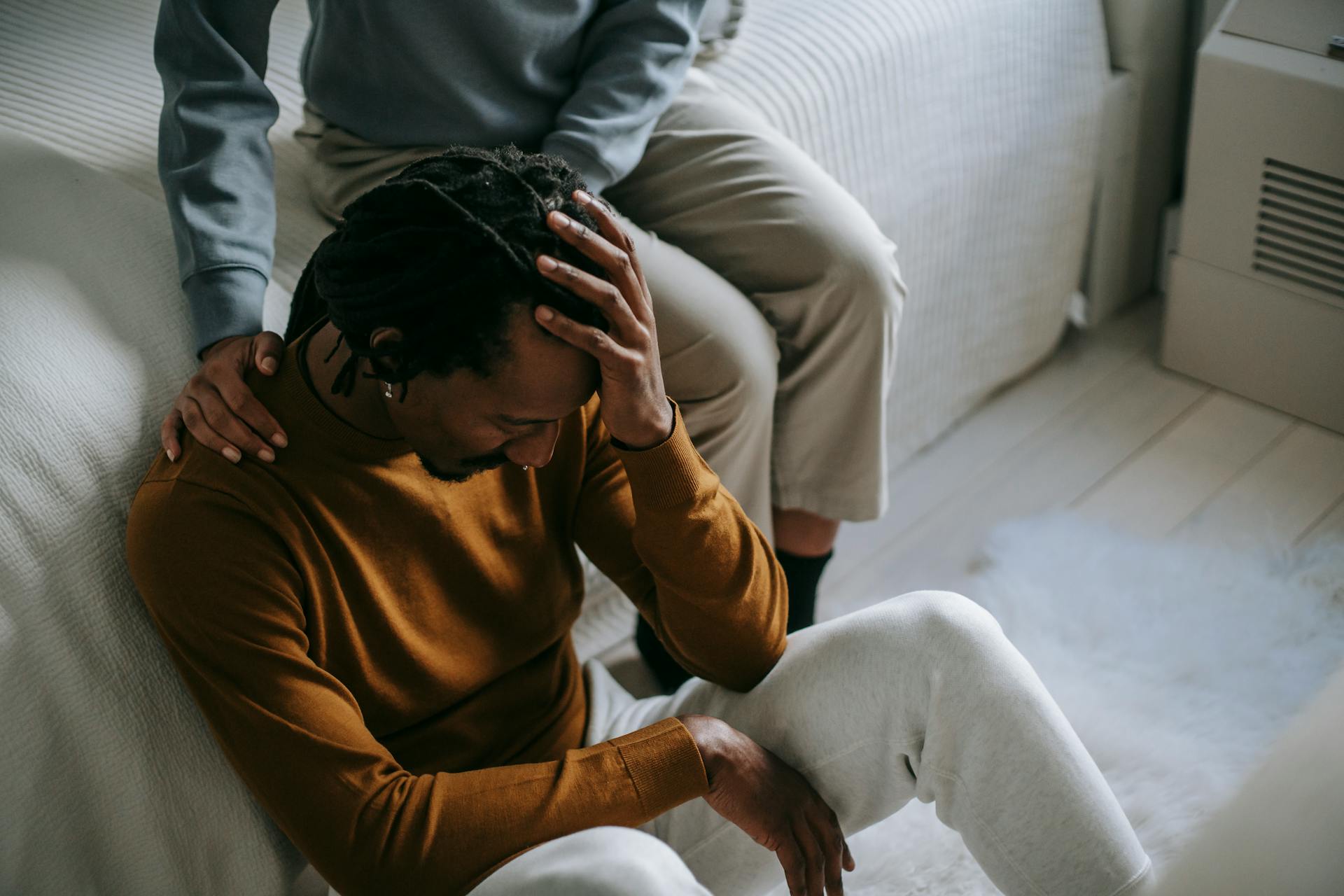 Young African American couple in casual clothes pastime with sad face and headache in room in daylight