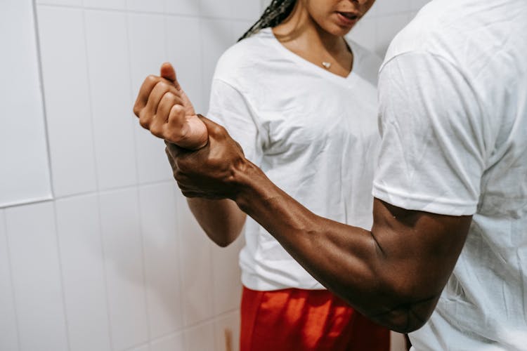 Crop Black Man Holding Arm Of Girlfriend During Conflict Indoors