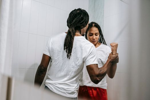 Unrecognizable violent black man fighting with girlfriend at home
