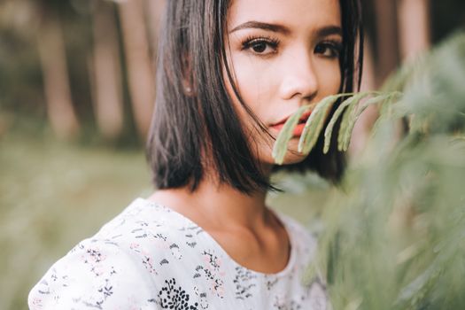 这是一张短发女子在宁静林地中的特写照片