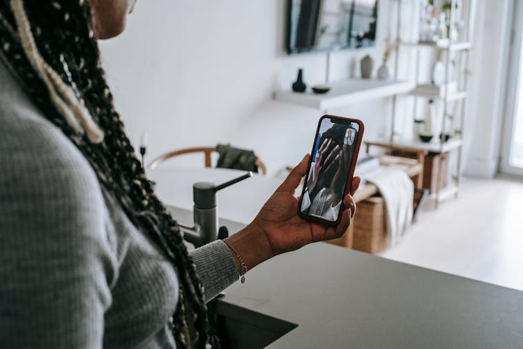 Anonymous Black Female Having Video Chat On Smartphone At Home