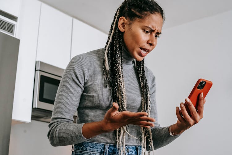 Annoyed Black Woman Having Video Chat On Smartphone At Home