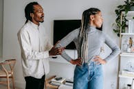 African American stylish man apologizing to sad girlfriend while having conflict at home