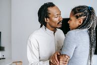 Ethnic man squeezing shoulder of girlfriend