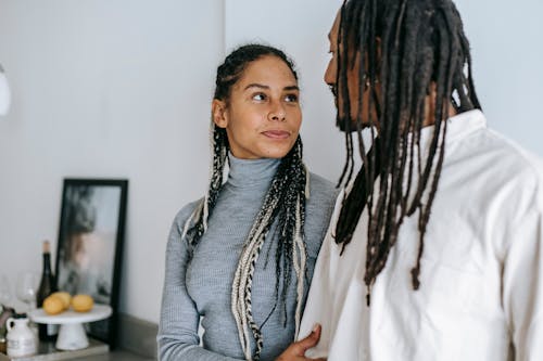 Free Ethnic couple with braids gently looking at each other Stock Photo