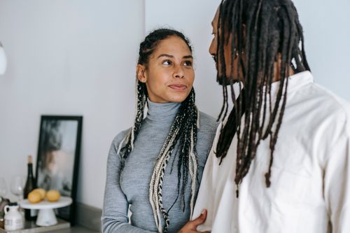 Free Loving ethnic couple in casual wear standing close and looking tenderly at each other Stock Photo