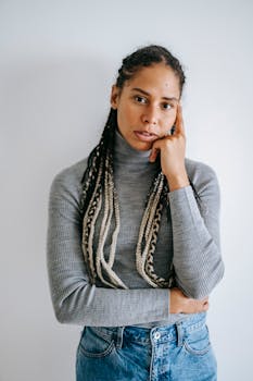 白色背景下，一位扎着辫子的年轻女子若有所思的肖像