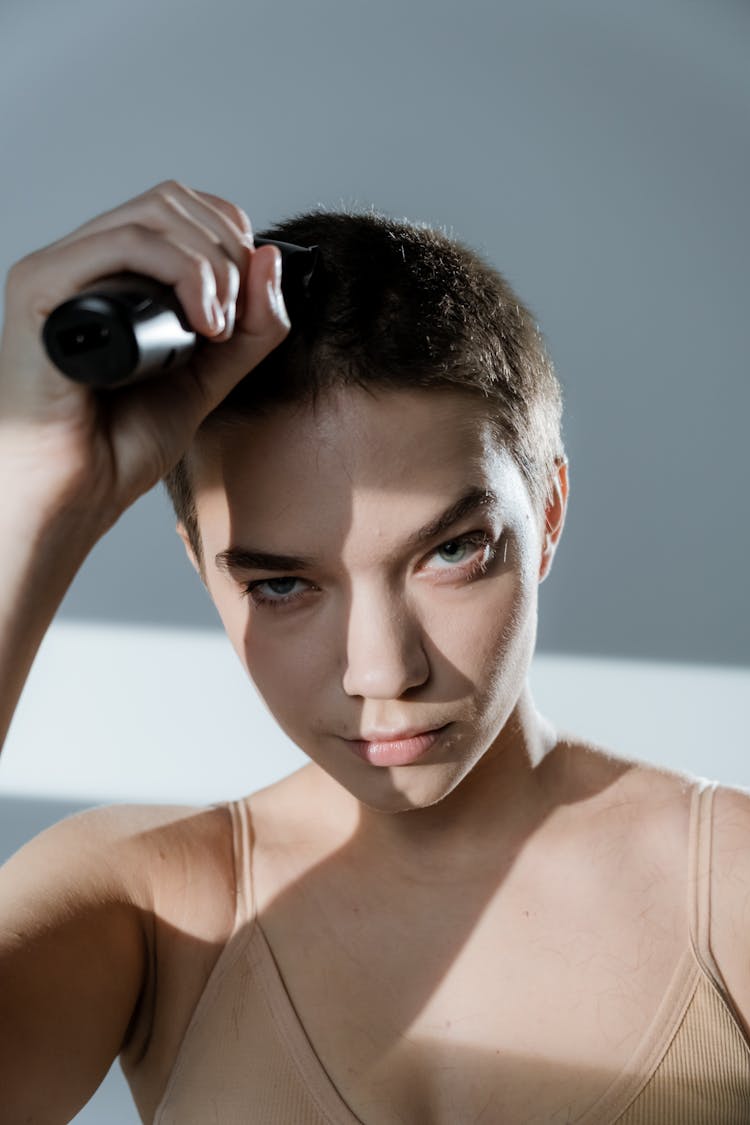 Close-up Shot Of A Woman Trimming Her Hair With A Razor