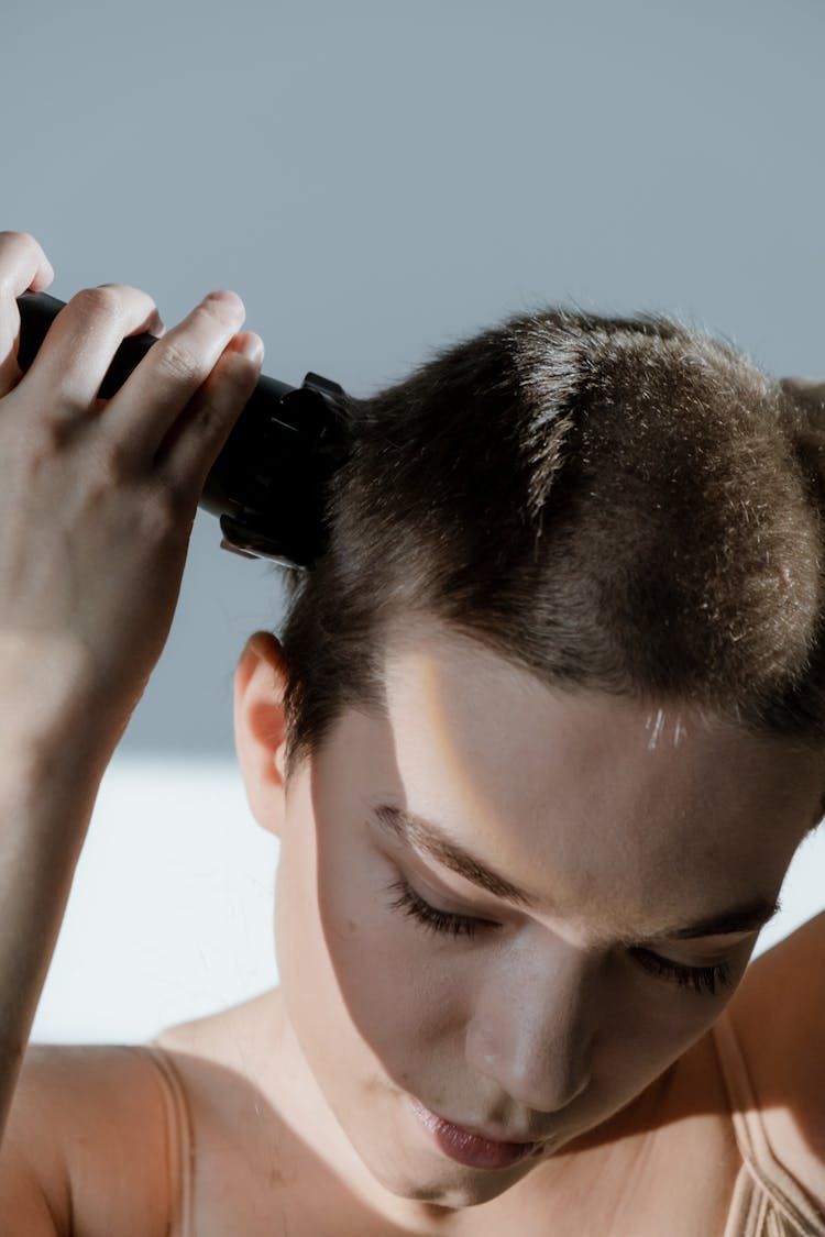 Close-Up Shot Of A Woman Trimming Her Hair With A Razor