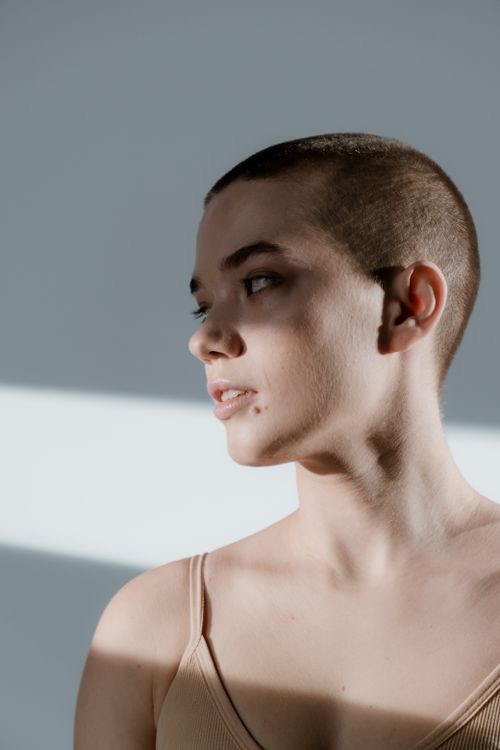 Free Artistic side view portrait of a young woman with short hair in studio lighting. Stock Photo